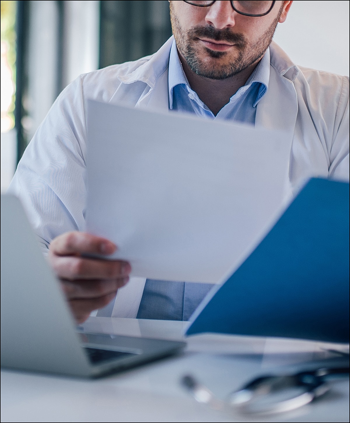 Laboratory technician holding test tubes in rack.