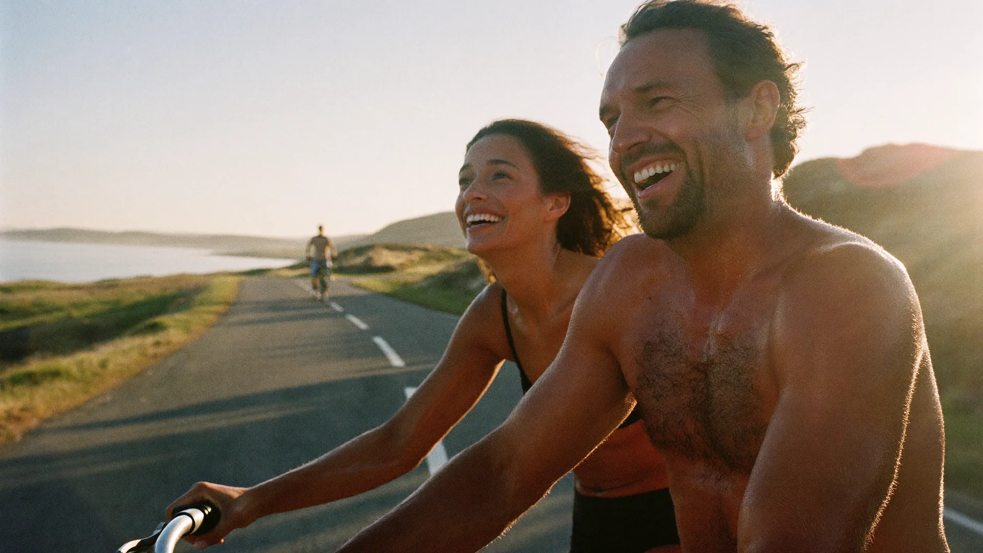 A couple in their forties on a morning bicycle ride along a quiet coastal road